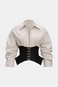 Beige shirt with a black corset belt featuring gold buckles on a white background