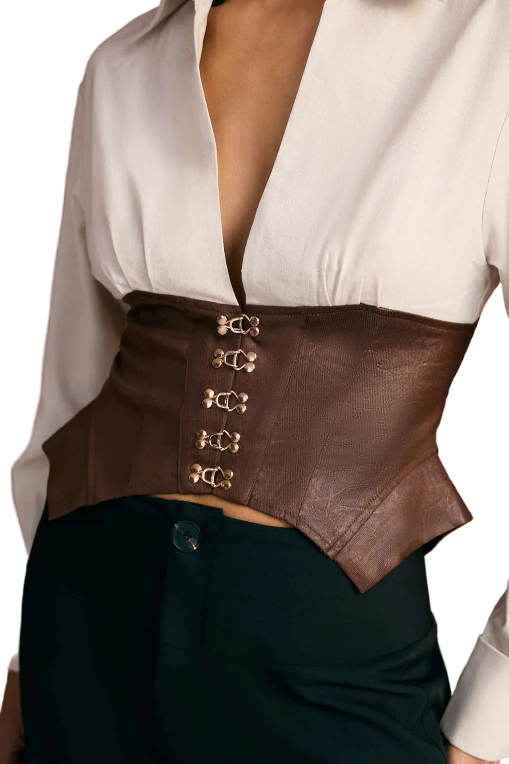 Brown leather corset with gold buckles worn over a white blouse and dark pants.